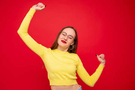Portrait of a young woman in a yellow jacket in a good moodの写真素材