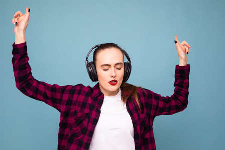 A young woman listens to music with headphones in a good moodの写真素材