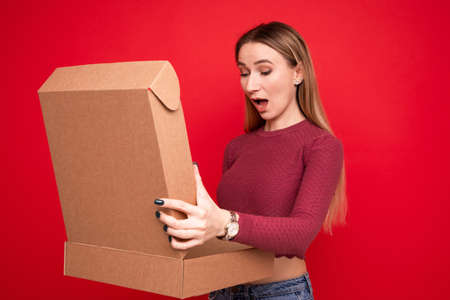 A young woman received a parcel in a cardboard boxの写真素材