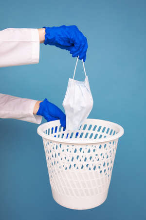 The doctor throws the used medical mask in the trashの写真素材