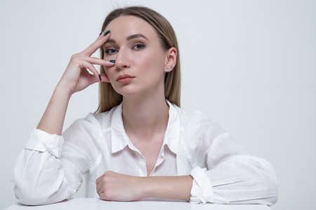 Portrait of a stylish young woman in a white shirtの写真素材
