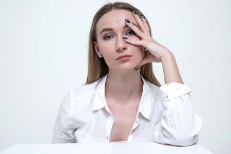 Portrait of a stylish young woman in a white shirtの写真素材