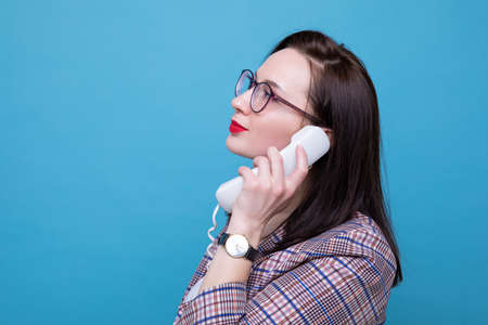 Portrait of a businesswoman talking on an office phoneの写真素材