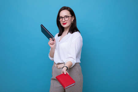 Portrait of a young brunette woman with a black and red diaryの写真素材