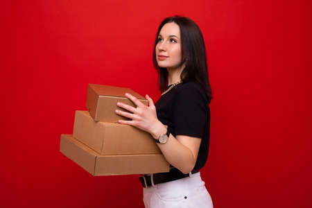 Young woman with paper boxes on red backgroundの写真素材