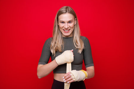 Young athletic woman bandages her hands before boxing trainingの写真素材