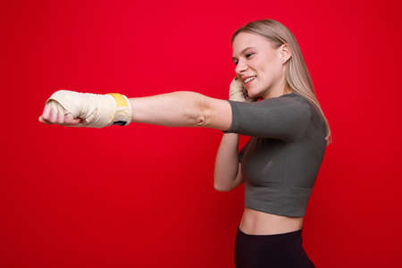 Athletic female boxer on red background