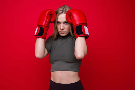 Athletic young woman in red boxing gloves in trainingの写真素材