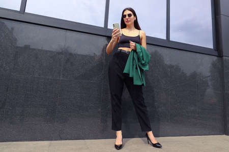 Portrait of a businesswoman with a mobile phone on the street