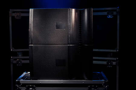Switched two sound speakers on the background of boxes with concert equipment