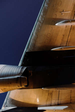 Close-up of the wing and engine of the aircraft against the background of the starry skyの写真素材