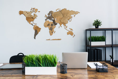 A wooden map hangs on a light wall in the office. A world map in a stylish interior.の写真素材