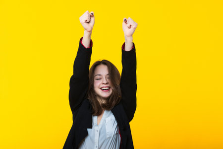 A successful decision in business. Portrait of a young woman on a yellow background.の写真素材
