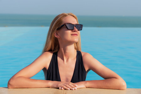 A young woman is swimming in an outdoor pool