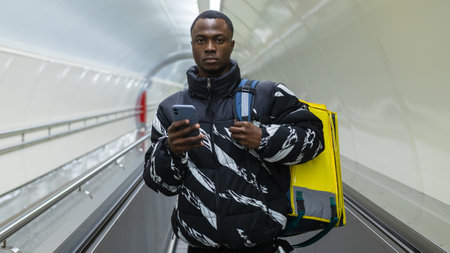 Panoramic photo of an African-American courier who is walking in the transition. Timely professional deliveryの写真素材