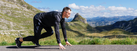 A runner is preparing to start against the backdrop of mountains. Panoramic photo of an athletic...