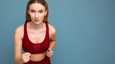 The athlete looks into the camera and runs on a blue isolated background