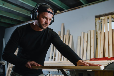 A professional master carpenter uses a circular sawing machineの写真素材