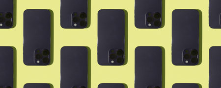 The concept of a pattern of mobile phones. A modern smartphone on a yellow backgroundの写真素材