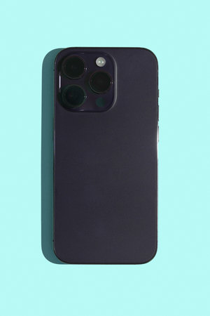 Smartphone on a turquoise background. The concept of cameras in phones