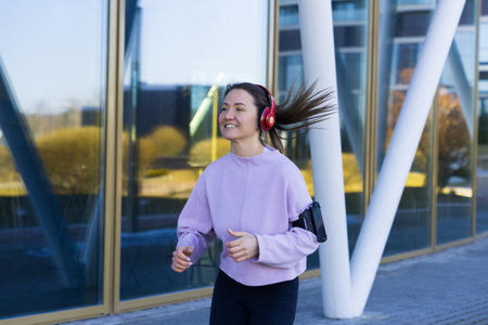 A smiling athlete is running on the street in a good mood. training outside