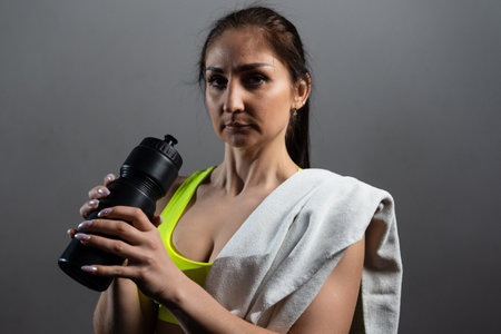 Portrait of a sporty woman who drinks water after a workoutの写真素材
