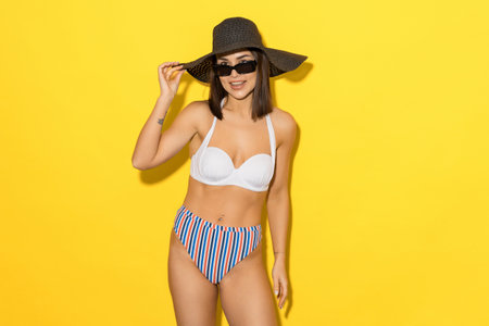 Summer holidays at the sea. Tanned female body in a swimsuit. A woman in a swimsuit on a bright backgroundの写真素材
