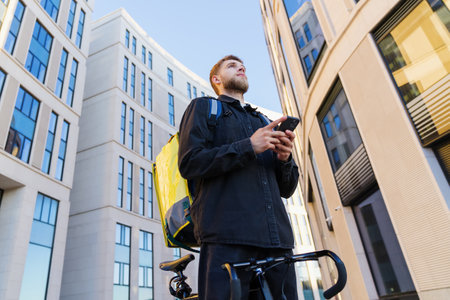 delivery in the city. The delivery guy is outside. A man with a yellow backpack on the background of...