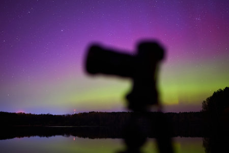 Photographing natural phenomena. The aurora borealis. In the foreground is a professional cameraの写真素材