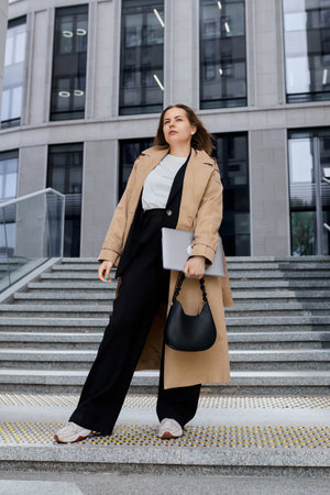 A professional in his field with laptops poses outside an office building. Modern boss, young...