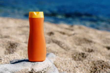 Sunscreen. vacation at sea. Orange bottle on the background of the beach. A means to protect the skin during tanningの写真素材