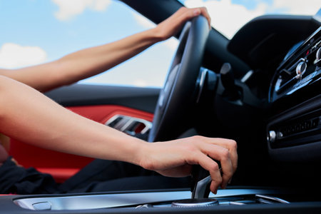 The woman turns on the transmission before driving the car. The concept of weekend travelの写真素材
