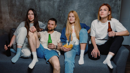 Friends watch the final of the football tournament at home on TVの写真素材