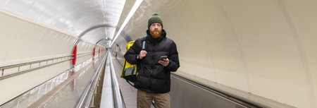 Panoramic photo of a male deliveryman in a subway crossingの写真素材