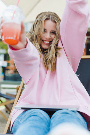 Portrait of a happy young woman with lemonade. A model in a summer cafe in a good moodの写真素材