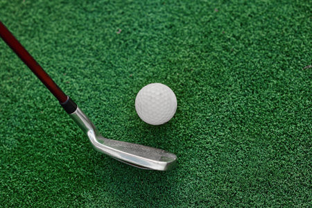 A vivid snapshot of a golf club, as a golfer focuses intensely on the ball resting atop the pristine...