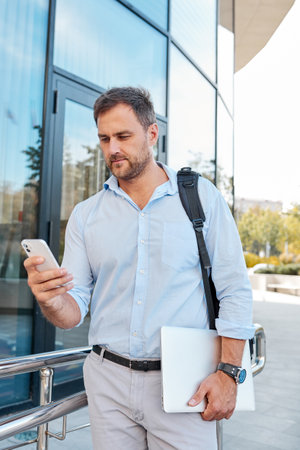 A business man dressed in a blue shirt walks around the city during a break at work.の写真素材
