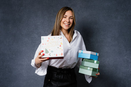 A happy young woman received gifts for the new year. Portrait of a joyful brunette before Christmasの写真素材