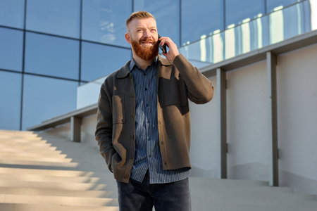 A man dressed in a shirt and jacket speaks on the phone.の写真素材