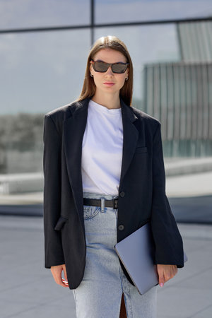 Young well-groomed confident woman working in business against the backdrop of a business center.の写真素材