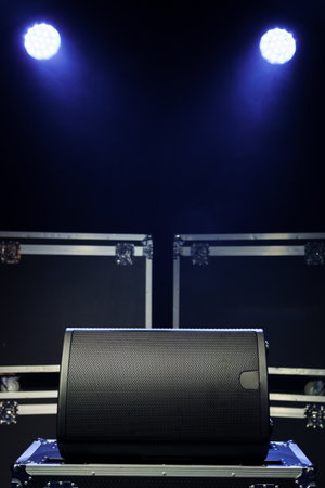 Sound speaker on the background of boxes with concert equipment.