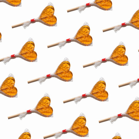 Repeating print of yellow candy hearts, valentine's day concept.