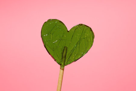 Snacks concept, heart shaped lollipops on pink background.の写真素材