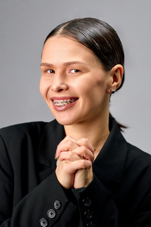 Bright young woman with braces smiling with open mouth.