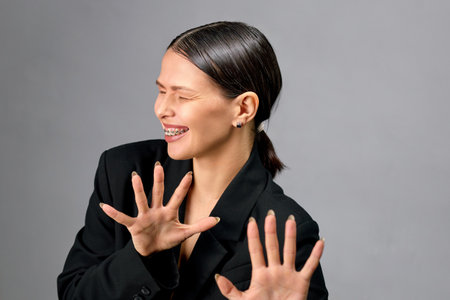 European emotional woman thought about something and opened her mouth showing braces.の写真素材