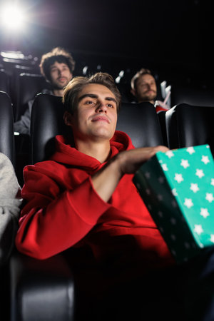 Vertical photo of a man in the center of the photo who is watching a movie in a cinemaの写真素材