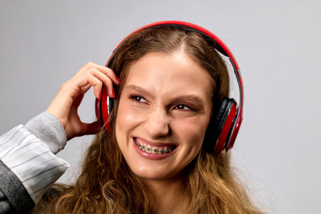 A woman wearing headphones smiles at the camera.