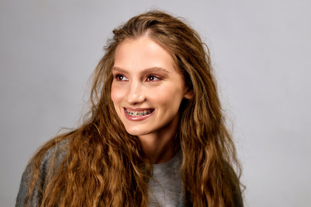 A woman displaying a smile with her long hair flowing.