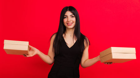 A young woman in two gift boxes on a red backgroundの写真素材