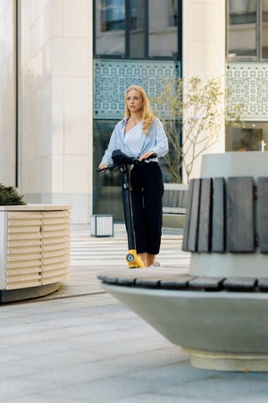 Free movement concept, young woman riding electric scooter on pedestrian street.の写真素材
